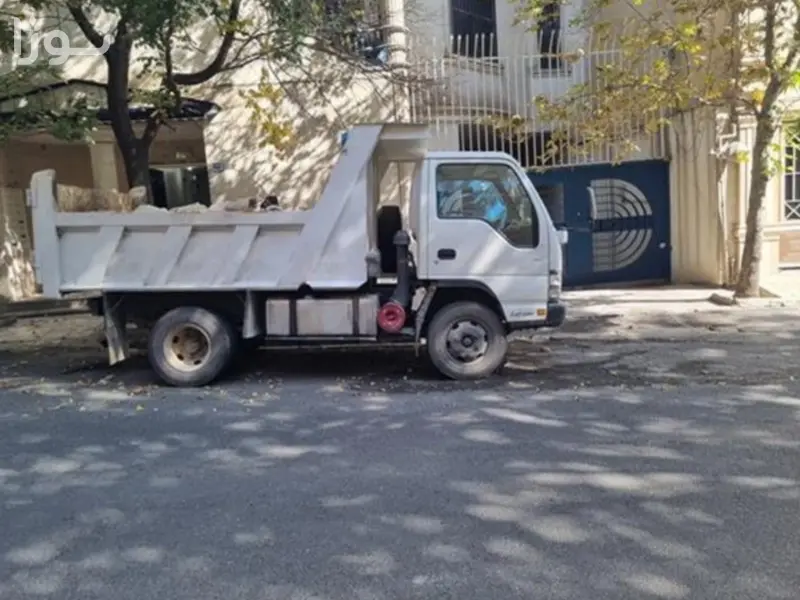 کامیونت کمپرسی بزرگ جورسرویس در حال تخلیه نخاله ساختمانی حجیم در یک پروژه تخریب در جورسرویس